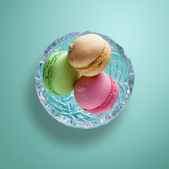  drei französische Macarons liegen in einer Glasschale