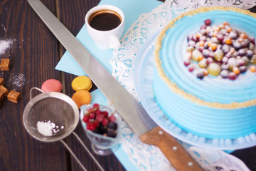Festive cake with blue cream decorated with berries. Homemade baking. Close-up.
