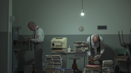 Multitasking office worker searching for files in his office