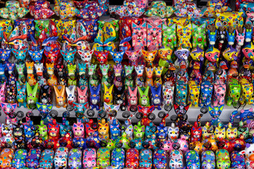 Fototapeta na wymiar Sale of souvenirs - funny handmade wooden animals in street market. Bright colorful children toys and decoration for interior. Ubud, Bali island, Indonesia. Closeup