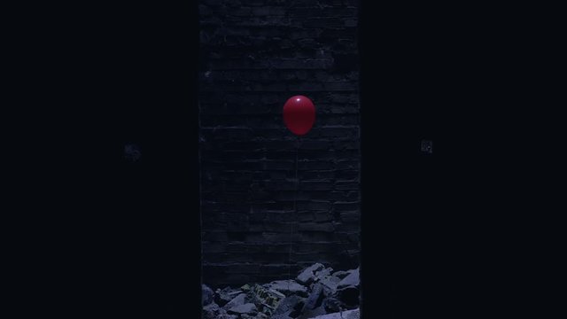 Single red balloon in abandoned building, blood-chilling horror symbol, thriller