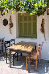 Front view of small cafe exterior. Table and empty chairs outdoor near the white wall. Tourist places. Typical Mediterranean restaurant, a place holidays in the summer