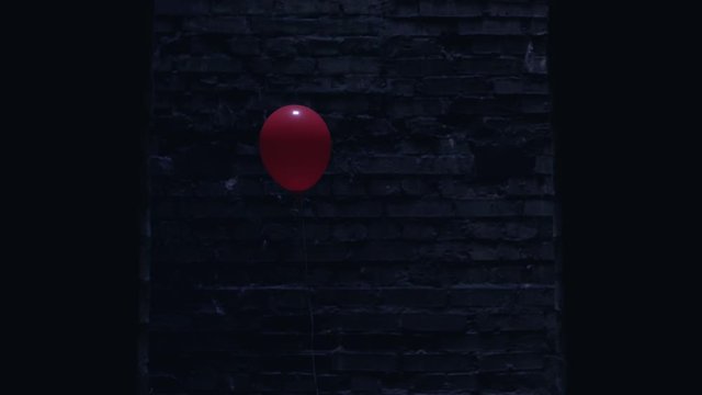 Red balloon appearing in scary dark place, symbol of upcoming danger, horror