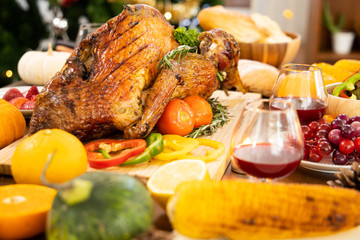 Roasted  chicken or turkey with sauce and grilled autumn vegetables: corn,pumpkin  on wooden table, top view, frame. Christmas or Thanksgiving Day food concept.