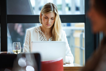 Businesswoman using laptop in a restaurant