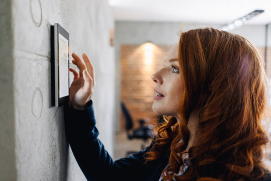 Businesswoman using device at a wall
