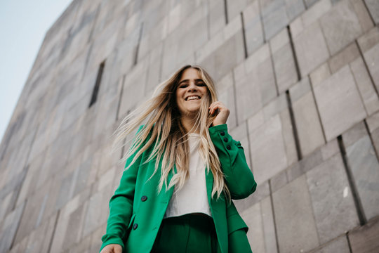 Portrait of laughing young woman wearing green pantsuit, Vienna, Austria