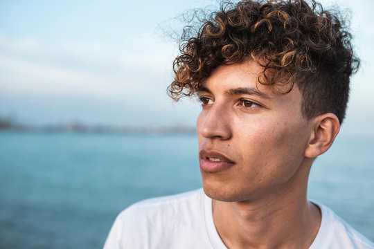 Portrait Of Young Man With Curly Hair By The Sea