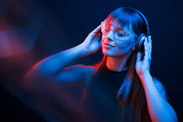 Conception of cyberpank and futurism. Studio shot in dark studio with neon light. Portrait of young...