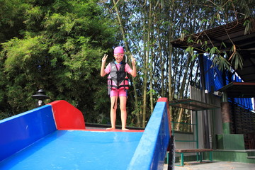 Girls playing with water slides,Happy little girl playing on water slide in outdoor swimming on hot summer day. 