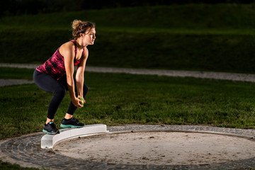 Femal shot-putter training with ball