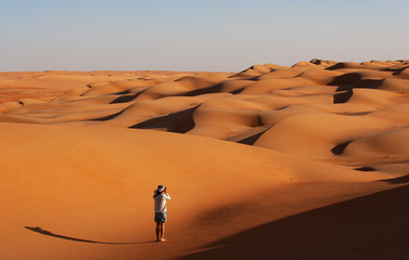 Man taking pictures in the desert, Wahiba Sands, Oman