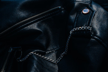 Silver chain pinned to black leather jacket