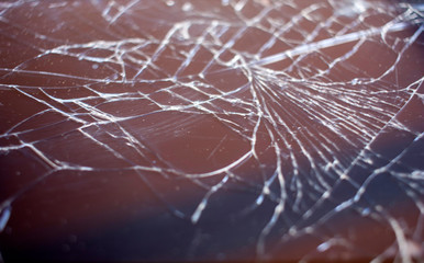 Cracked smart phone screen close-up. Broken glass texture background with cracks.