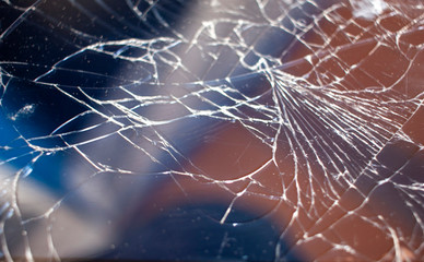 Cracked smart phone screen close-up. Broken glass texture background with cracks.