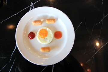 The fried egg on a white plate.