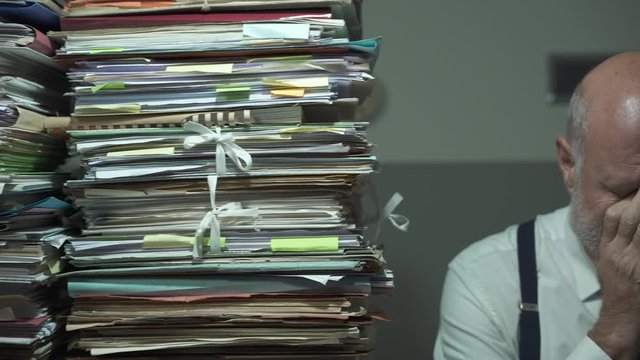 Depressed stressed businessman with lots of paperwork