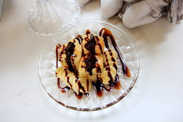 Toast with bananas topping with chocolate,That sweet on the table glass.