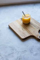 sea ​​buckthorn juice in a jar on a wooden board with concrete worktop