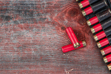 Hunting cartridges in patronage are lying on a wooden table close-up. The hunting period, the...