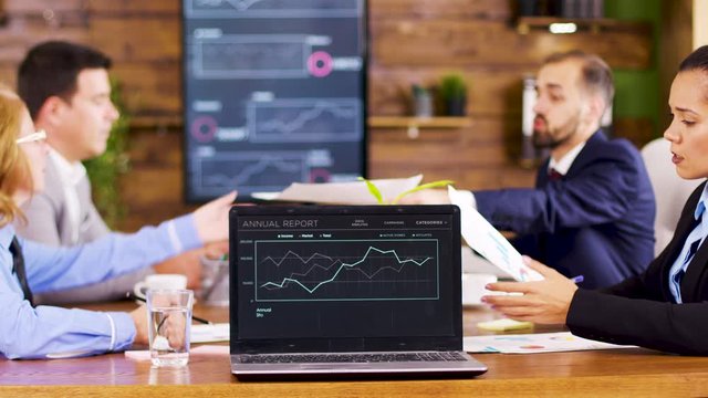 On the table laptop showing charts in the conference room