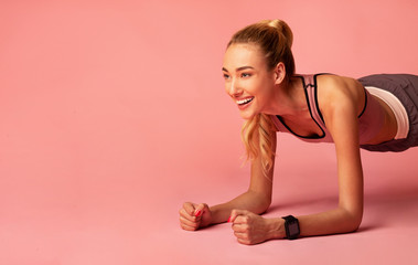 Obraz na płótnie Canvas Fitness Girl Doing Plank Exercise Over Pink Studio Background