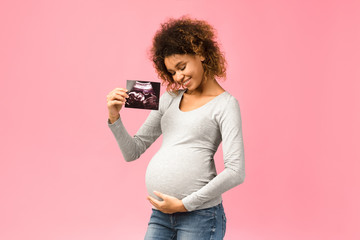 Happy afro pregnant woman with her baby sonography