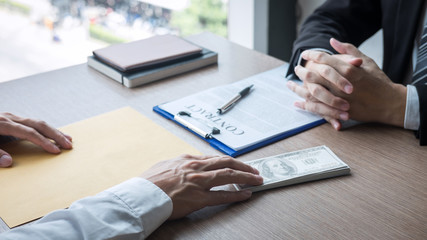 Dishonest cheating in illegal money, Businessman giving bribe money the form of dollar bills to while give success the deal to contract agreement, Bribery and corruption concept