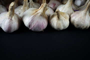 Shot of several whole garlic bulbs grouped on black plate