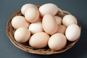 Chicken eggs in a small basket on a dark background.  Natural products, healthy food.