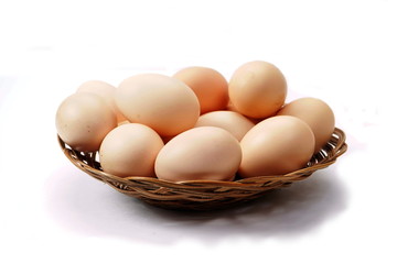 Chicken eggs in a small basket on a white background. Natural products, healthy food.