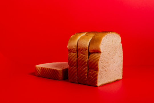 Four slices of bread on red surface