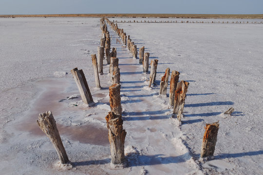 Panoramic view of parallel wooden posts at salt pan