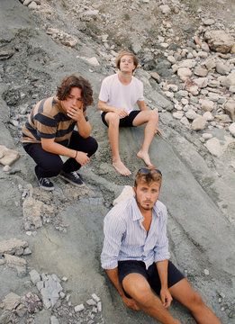 Three young men relaxing on rock