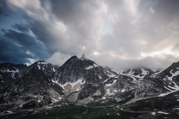 Snow covered barren mountains and storm clouds