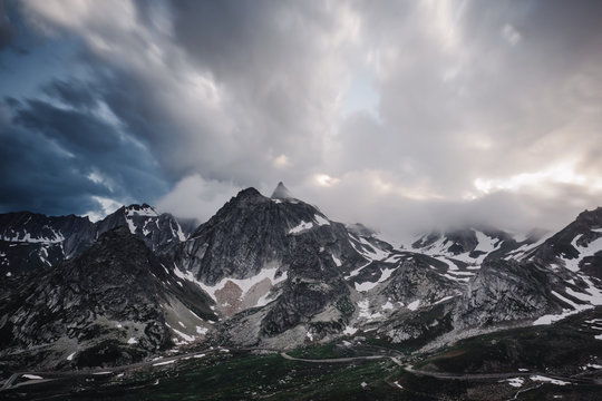 Snow covered barren mountains and storm clouds