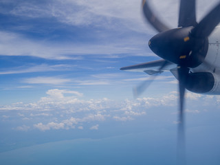 Naklejka na ściany i meble Clouds from airplane window with blue sky and high angle ground