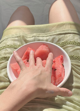 Midsection of woman holding bowl of watermelon