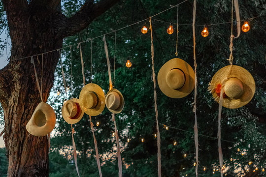 Straw hats hanging on&dagger;string light