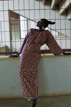Woman in dress leaning on wall