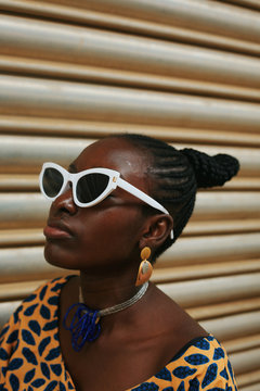 Woman wearing sunglasses standing in front of shutter