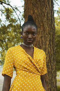 Portrait of woman in dress standing in park