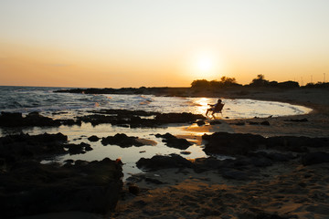 a man sitting in an armchair and admiring the sunset. The concept of happiness, relaxation, vacation. Self-development and self-absorption, meditation