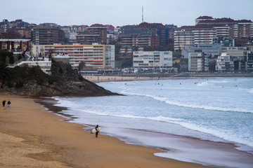 Playa con olas y persona que hace surf