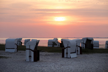 Abendstimmung am Wattenmeer an der Nordsee am Strand von Harlesiel mit Sonnenuntergang und weißen Strandkörben - Stockfoto