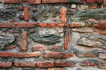 Antique gray stone wall framed by red brick. Turkish masonry.