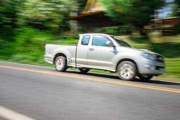 Blurry speedy movement of pickup truck driving on road - obrazy, fototapety, plakaty