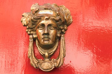  Valletta, Malta, August 2019. Old bronze doorknob on a red background. 
