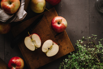Apple cut in half on wooden cutting board