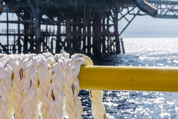 Hawser rope on hung on handrail of a consrution barge at oil field